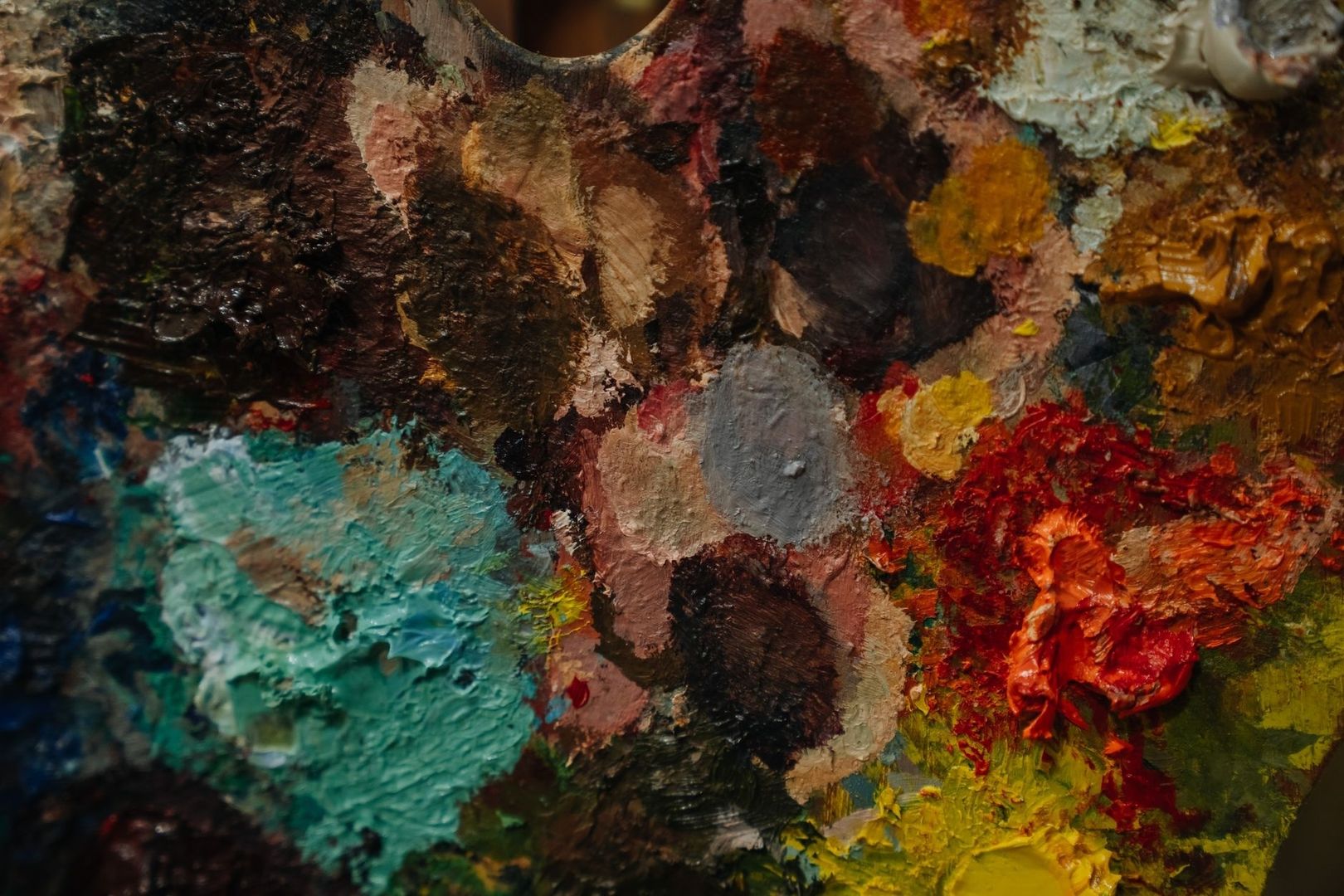 Nahaufnahme einer Palette mit dicken, farbigen Ölfarben in vielen Farbtönen